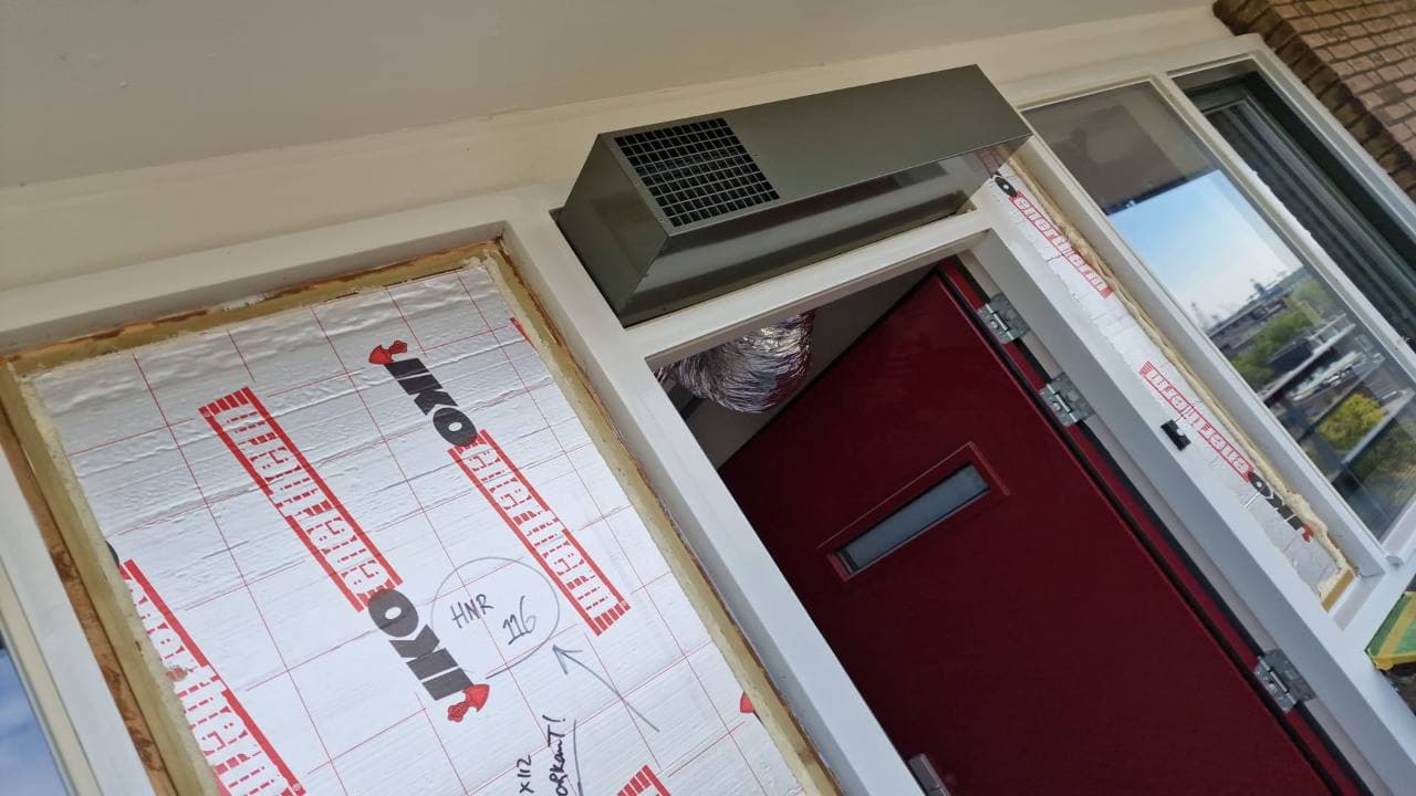 Buitenluchtaansluiting boven de voordeur van een appartement in Schiedam